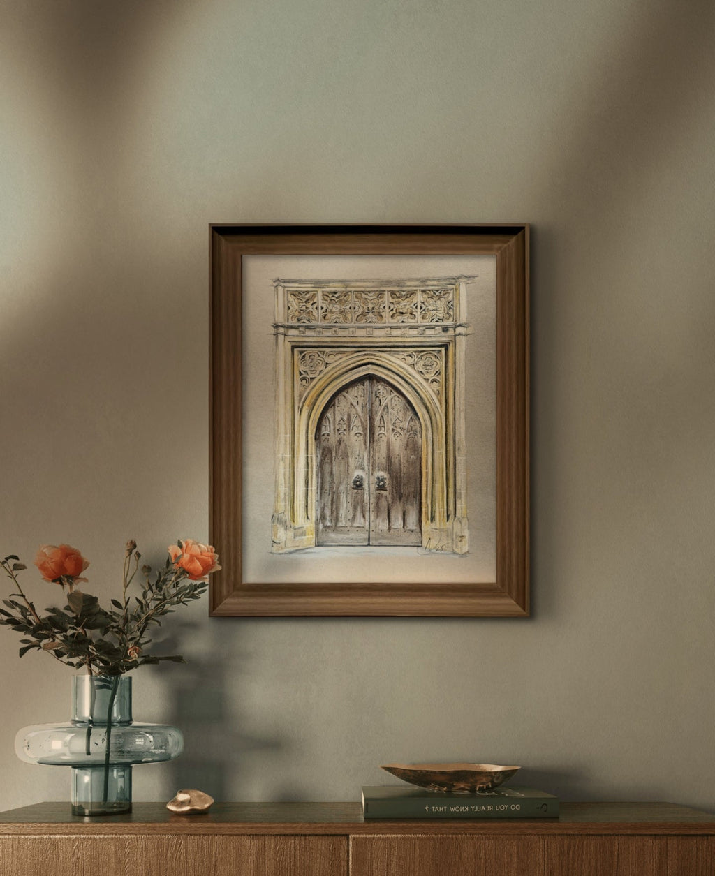 Framed artwork on a wall above a wooden console table with decorative items.